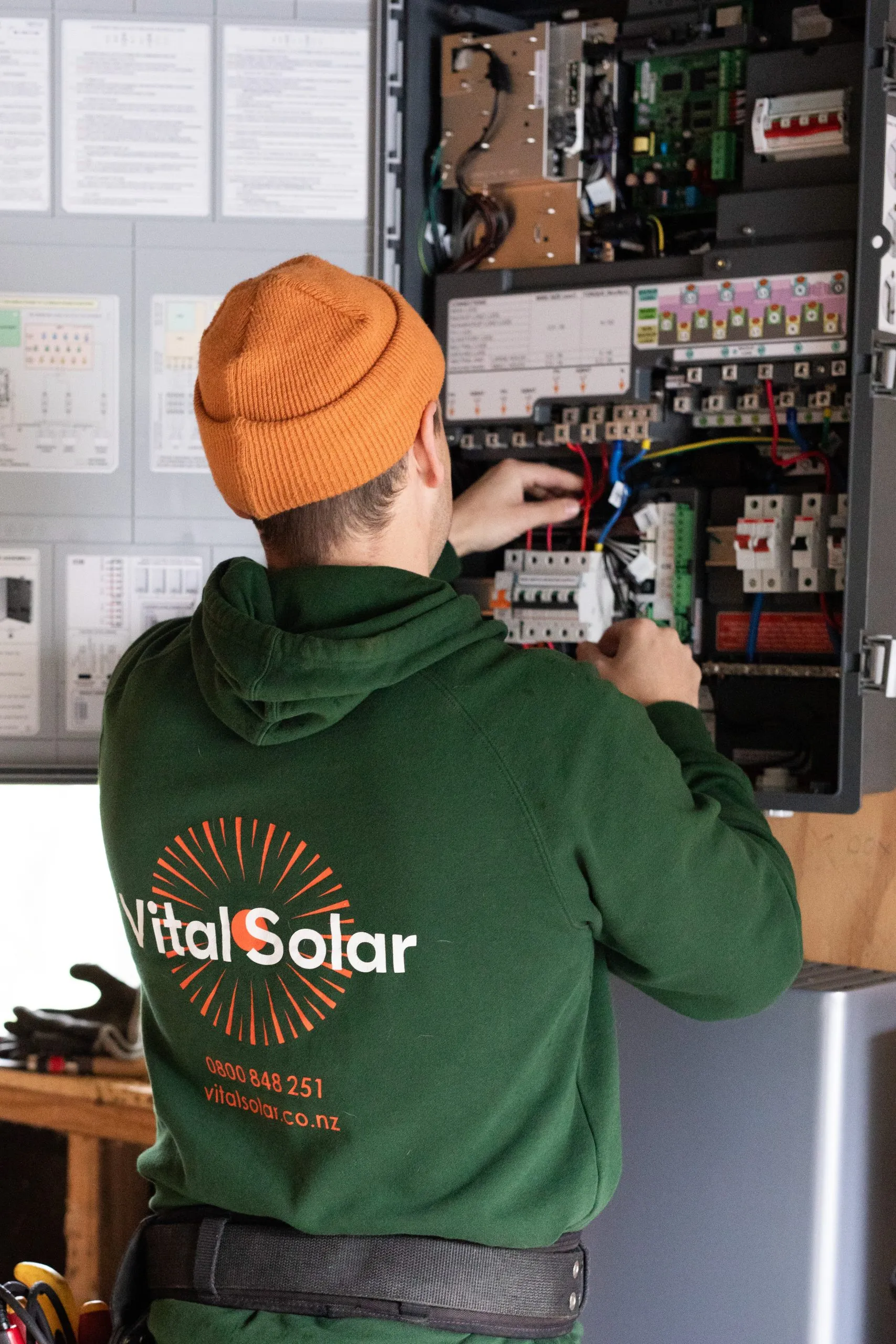 Vital Energy electrician working inside a residential switchboard in Auckland